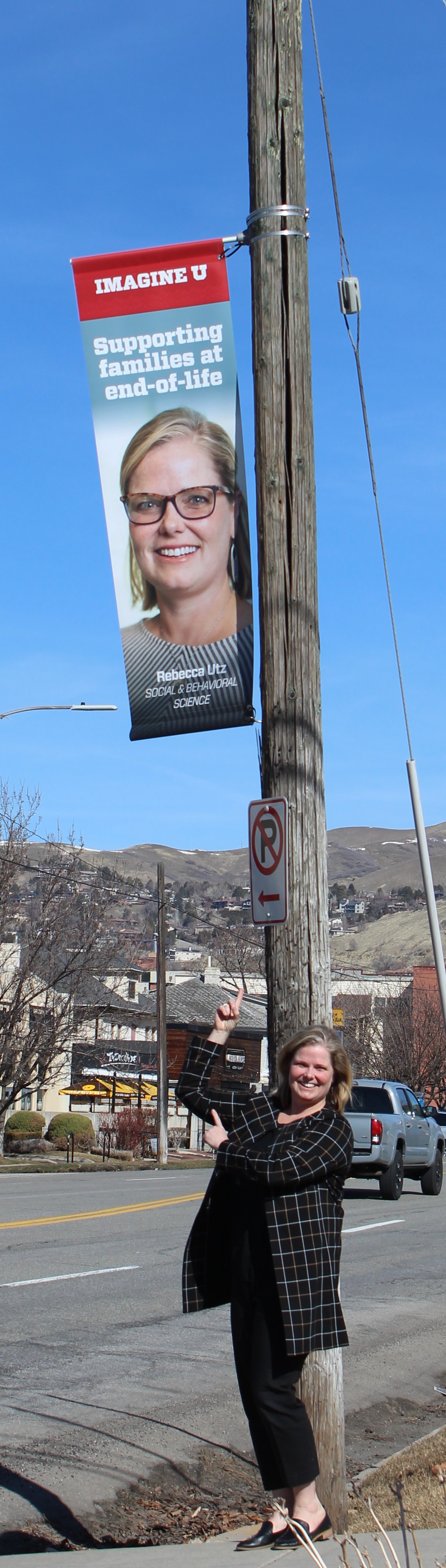 street banner with Rebecca Utz's face and Rebecca Utz standing beneath